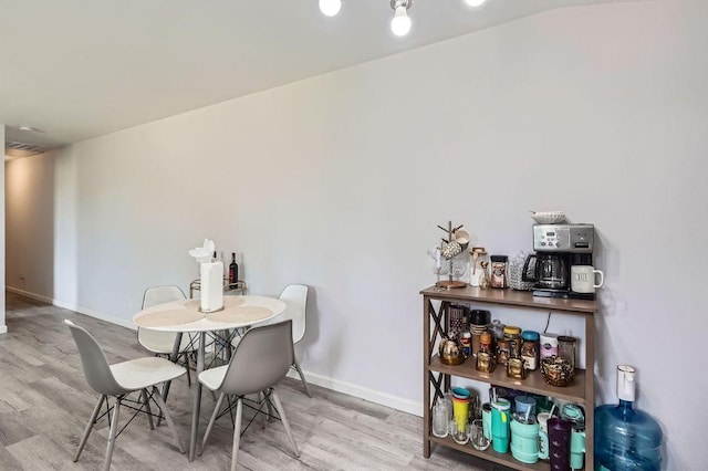 dining space with wood finished floors and baseboards
