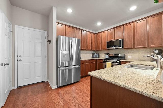 3101 Davis Ln Unit 6402, Austin, TX 78748 - kitchen with stainless steel appliances, a sink, light wood-style floors, light stone countertops, and recessed lighting