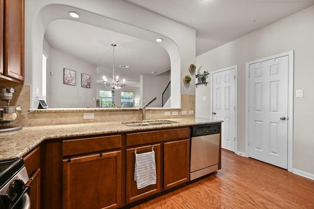 3101 Davis Ln Unit 6402, Austin, TX 78748 - kitchen featuring appliances with stainless steel finishes, a sink, arched walkways, light wood-style flooring, and backsplash