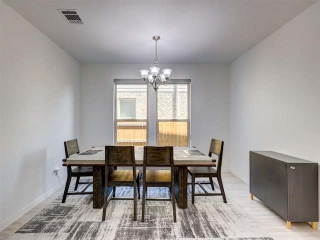 617 Silent Creek Cv, Georgetown, TX 78628 - dining room with a chandelier, light wood-style floors, and baseboards