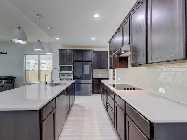 617 Silent Creek Cv, Georgetown, TX 78628 - kitchen featuring appliances with stainless steel finishes, a sink, under cabinet range hood, tasteful backsplash, and dark brown cabinets