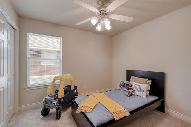 carpeted bedroom featuring baseboards and a ceiling fan
