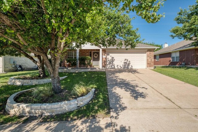 1303 Ridgewood Dr, Leander, TX 78641 - view of front of property with brick siding, an attached garage, concrete driveway, and a front lawn