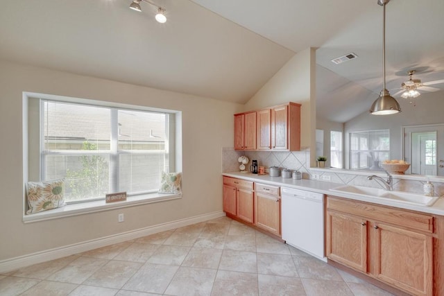 kitchen with white dishwasher, a sink, vaulted ceiling, tasteful backsplash, and light countertops