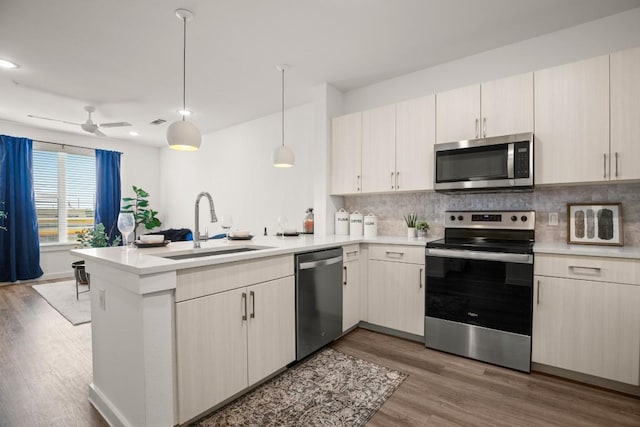 6324 N Lamar Blvd Unit 212, Austin, TX 78752 - kitchen featuring appliances with stainless steel finishes, a sink, a peninsula, light countertops, and recessed lighting