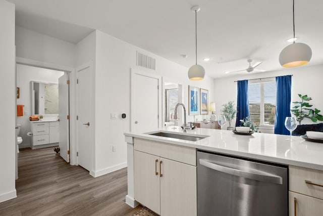 6324 N Lamar Blvd Unit 212, Austin, TX 78752 - kitchen with dishwasher, a sink, light countertops, wood finished floors, and hanging light fixtures