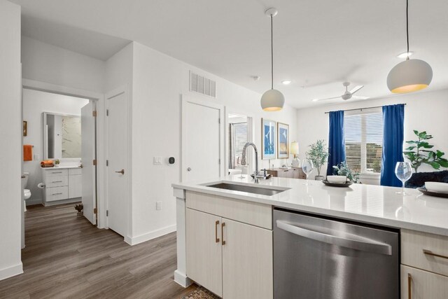 6324 N Lamar Blvd Unit 212, Austin, TX 78752 - kitchen featuring stainless steel dishwasher, a sink, light countertops, wood finished floors, and pendant lighting