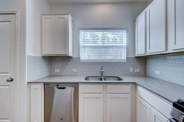 kitchen with dishwasher, a sink, decorative backsplash, and white cabinetry