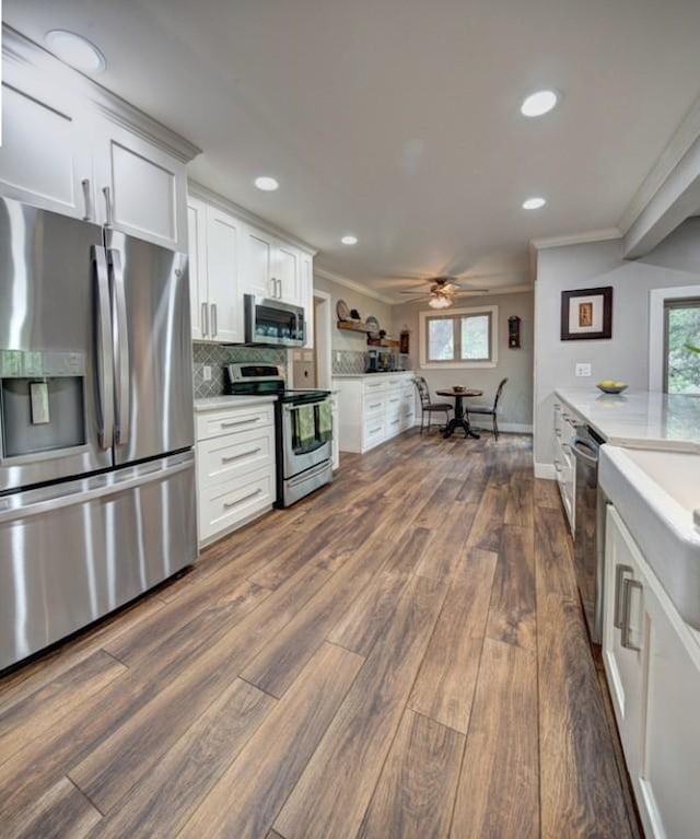 11408 Spicewood Pkwy, Austin, TX 78750 - kitchen with stainless steel appliances, light countertops, ornamental molding, dark wood finished floors, and a ceiling fan