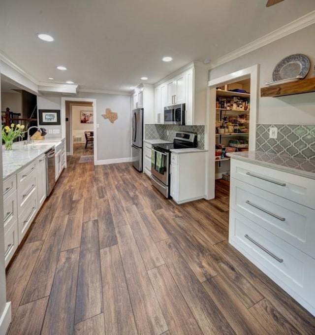 11408 Spicewood Pkwy, Austin, TX 78750 - kitchen featuring stainless steel appliances, crown molding, white cabinetry, recessed lighting, and backsplash