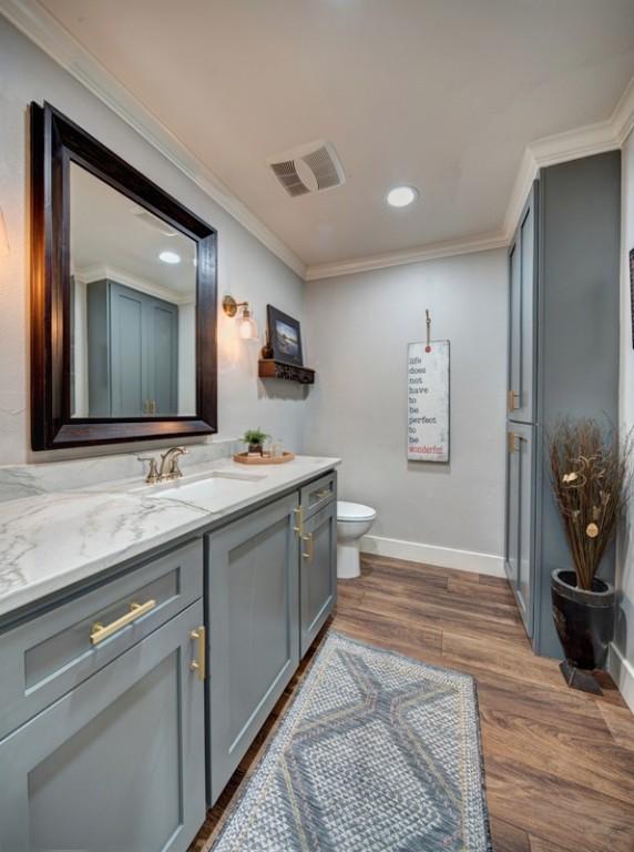 11408 Spicewood Pkwy, Austin, TX 78750 - bathroom featuring vanity, wood finished floors, ornamental molding, and recessed lighting