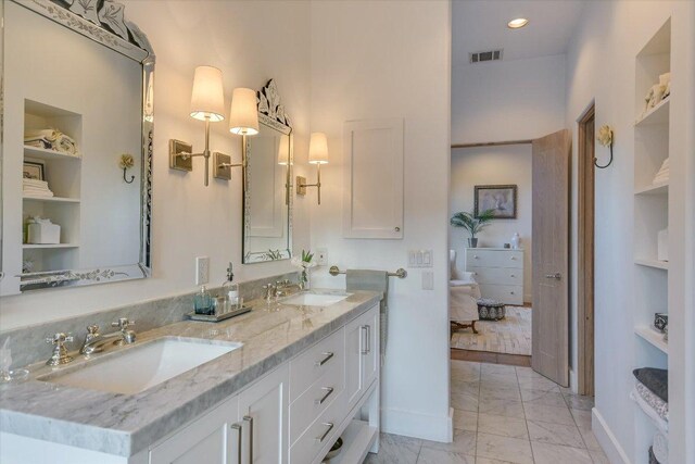 698 Windsong Trl, West Lake Hills, TX 78746 - bathroom featuring marble look tile flooring, baseboards, built in shelves, and double vanity