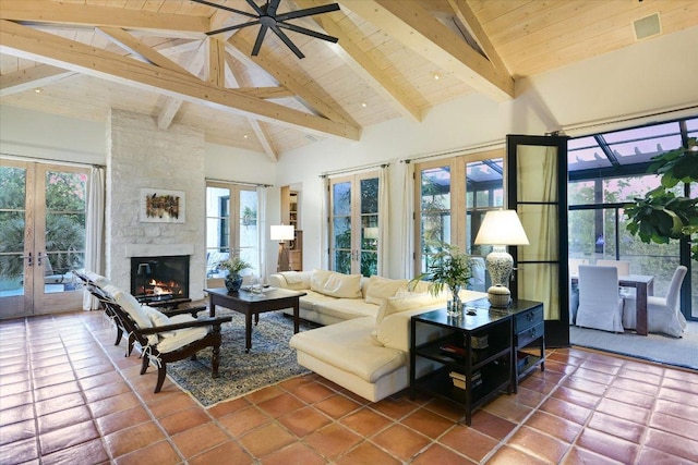 698 Windsong Trl, West Lake Hills, TX 78746 - tiled living area with french doors, beam ceiling, a stone fireplace, high vaulted ceiling, and wood ceiling