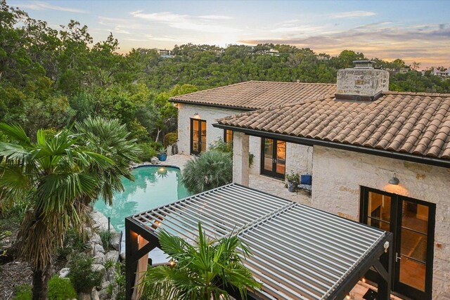 698 Windsong Trl, West Lake Hills, TX 78746 - back of property with a tiled roof, an outdoor pool, french doors, a chimney, and a patio
