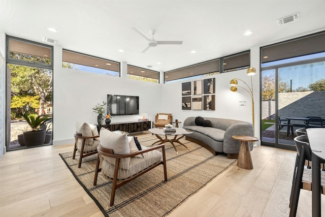 living area with ceiling fan and light wood-type flooring