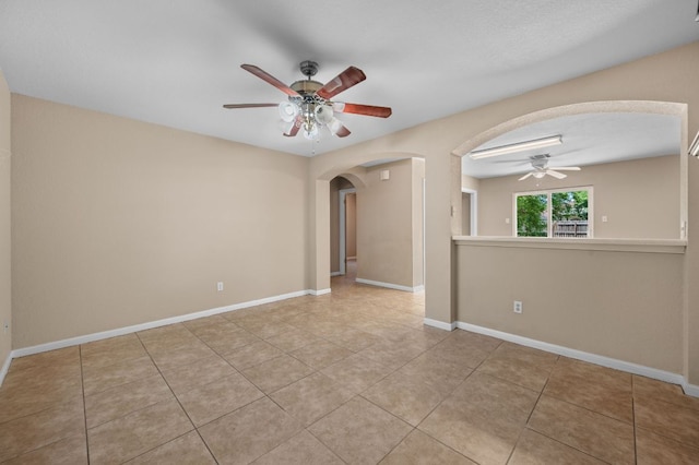 141 Britni Loop, Kyle, TX 78640 - tiled spare room with a ceiling fan, arched walkways, and baseboards