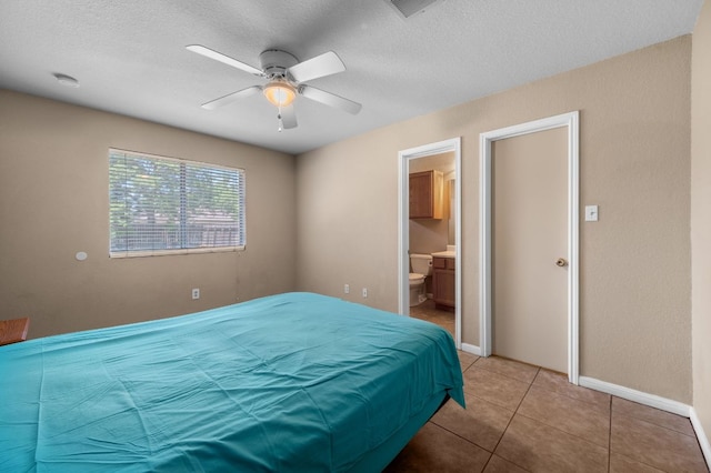 141 Britni Loop, Kyle, TX 78640 - bedroom with baseboards, a textured ceiling, light tile patterned flooring, ensuite bath, and a ceiling fan
