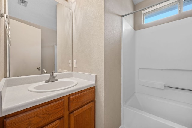 141 Britni Loop, Kyle, TX 78640 - full bath with vanity,  shower combination, and a textured wall
