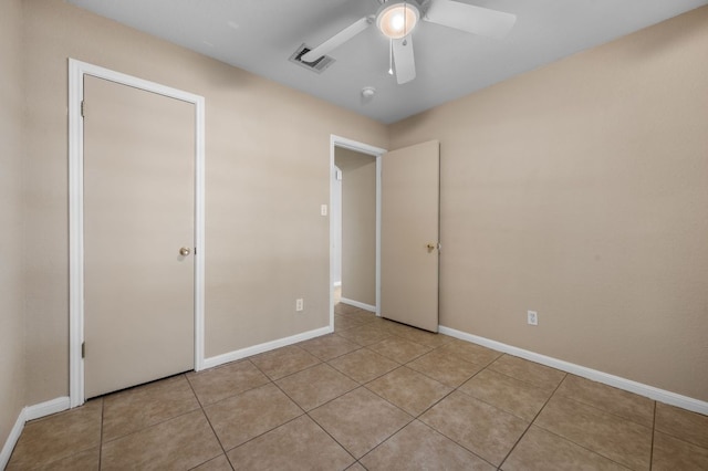 141 Britni Loop, Kyle, TX 78640 - unfurnished bedroom featuring light tile patterned floors, a ceiling fan, and baseboards