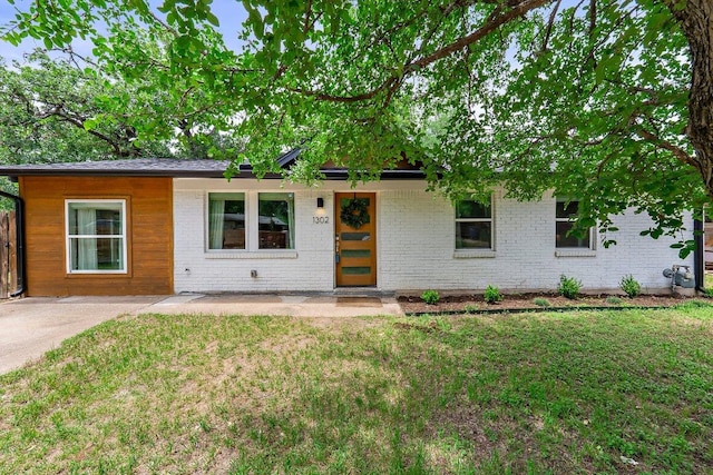1302 Astor Pl, Austin, TX 78721 - ranch-style house featuring a front yard and brick siding