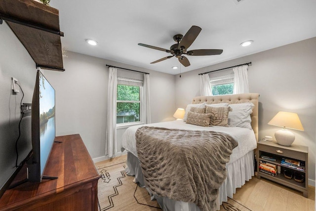 1302 Astor Pl, Austin, TX 78721 - bedroom with multiple windows, light wood finished floors, recessed lighting, ceiling fan, and baseboards