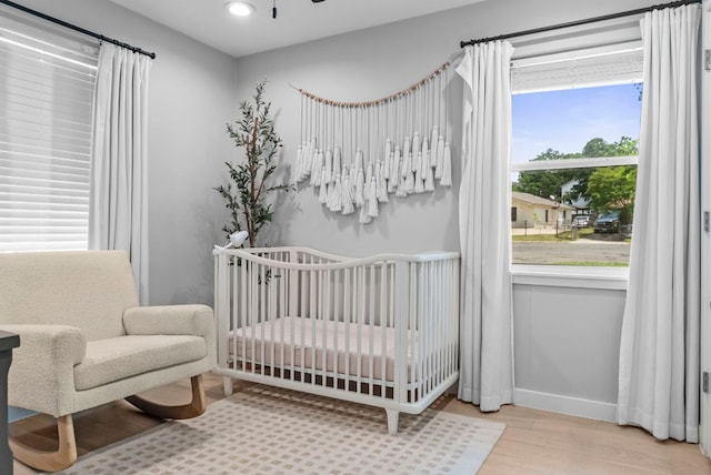 1302 Astor Pl, Austin, TX 78721 - bedroom with wood finished floors, a crib, baseboards, and recessed lighting