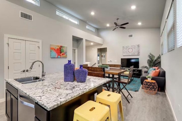 2709 E 2nd St Unit A, Austin, TX 78702 - kitchen featuring dishwasher, a high ceiling, ceiling fan, light wood-style floors, and open floor plan