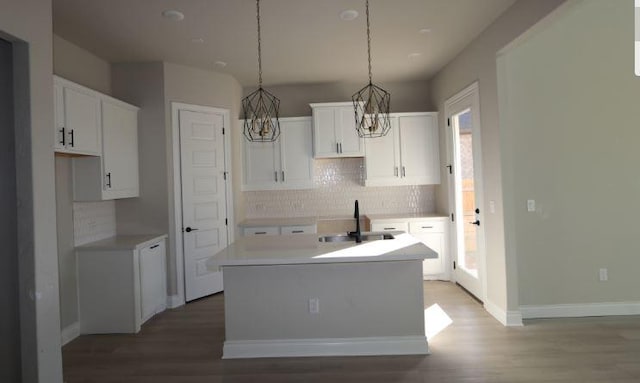 11804 Shimmering Sea Dr, Austin, TX 78747 - kitchen with an island with sink, a sink, a chandelier, tasteful backsplash, and wood finished floors