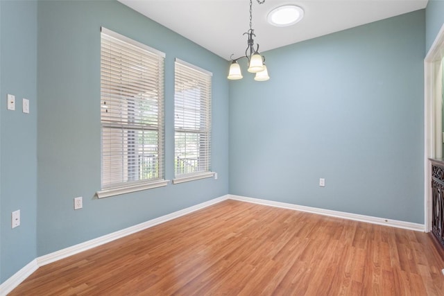 138 Dewberry Dr, Georgetown, TX 78633 - empty room featuring a chandelier, light wood-style flooring, and baseboards