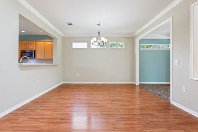 138 Dewberry Dr, Georgetown, TX 78633 - unfurnished dining area with a chandelier, light wood-style floors, baseboards, and crown molding