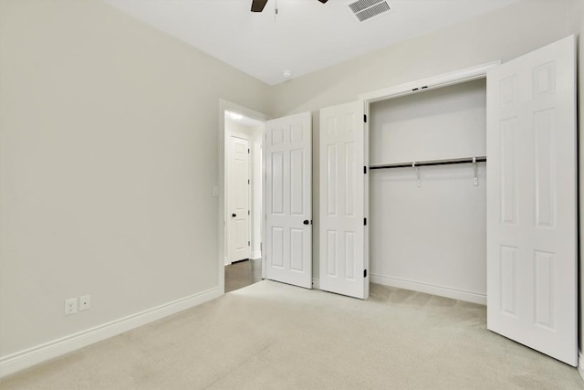 unfurnished bedroom with light carpet, baseboards, and a closet