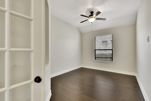 empty room featuring dark wood-style floors, ceiling fan, baseboards, and lofted ceiling