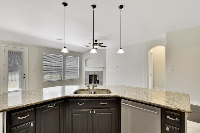 kitchen featuring dishwasher, a sink, a ceiling fan, arched walkways, and open floor plan