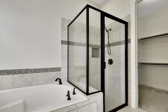 bathroom with a shower stall, a spacious closet, and a garden tub