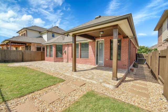 rear view of property featuring brick siding, a patio area, and central AC unit