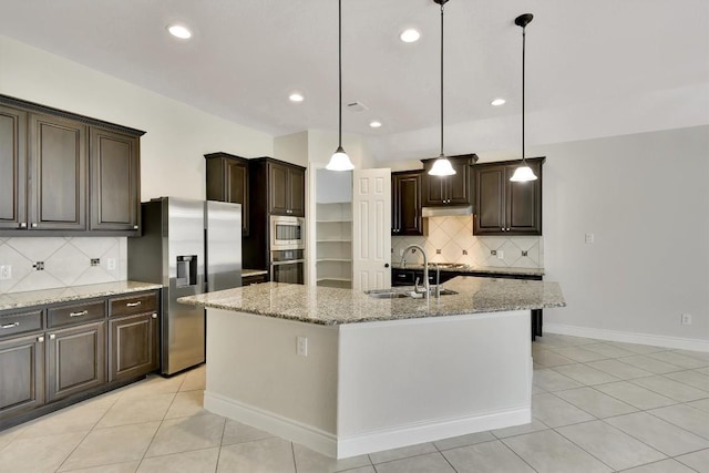 kitchen featuring appliances with stainless steel finishes, dark brown cabinetry, tasteful backsplash, light tile patterned floors, and light stone counters