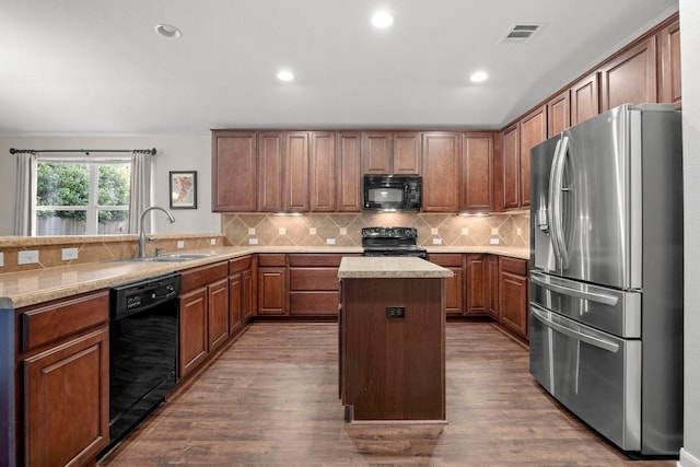 7613 Buck Meadow Dr, Georgetown, TX 78628 - kitchen featuring black appliances, a sink, a peninsula, dark wood-style flooring, and a kitchen island