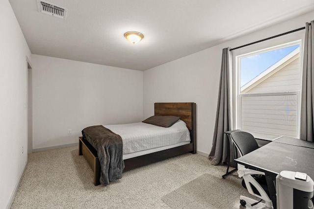 carpeted bedroom featuring baseboards and a desk