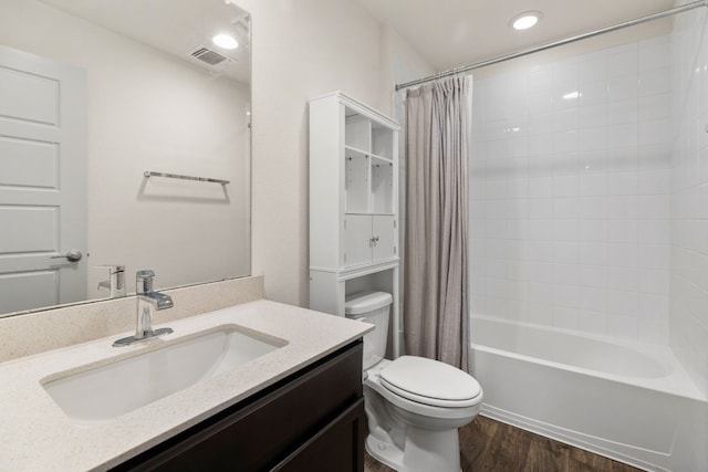 bathroom with toilet, wood finished floors, shower / tub combo with curtain, and vanity