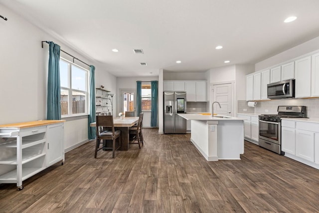 kitchen with stainless steel appliances, a sink, recessed lighting, dark wood-style flooring, and tasteful backsplash