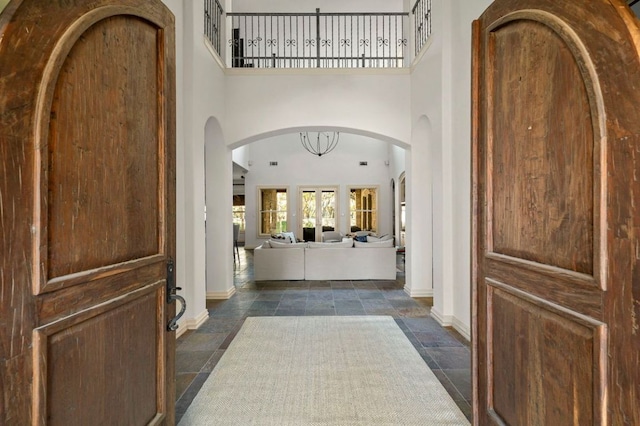 5902 Saratoga Cv, Austin, TX 78746 - entrance foyer with stone tile floors, a high ceiling, and arched walkways