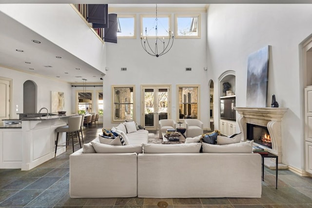 5902 Saratoga Cv, Austin, TX 78746 - living room featuring a chandelier, plenty of natural light, arched walkways, a high end fireplace, and a high ceiling