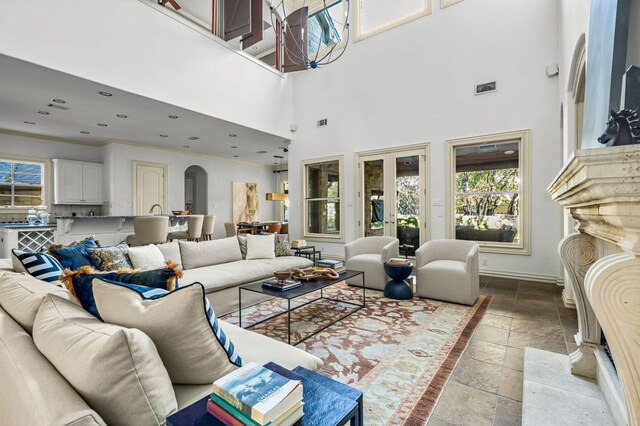 5902 Saratoga Cv, Austin, TX 78746 - living area featuring stone tile flooring, a towering ceiling, arched walkways, and recessed lighting