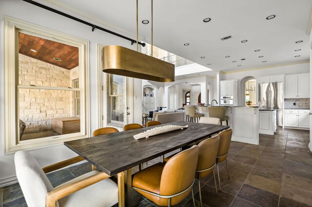 5902 Saratoga Cv, Austin, TX 78746 - dining space featuring arched walkways, stone tile flooring, vaulted ceiling, and wood ceiling