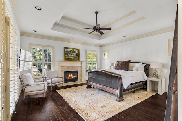 5902 Saratoga Cv, Austin, TX 78746 - bedroom featuring multiple windows, dark wood finished floors, ornamental molding, a glass covered fireplace, and a tray ceiling