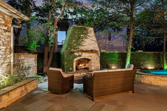 5902 Saratoga Cv, Austin, TX 78746 - patio terrace at dusk with an outdoor stone fireplace and a patio area