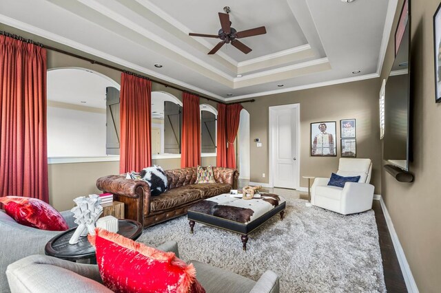 5902 Saratoga Cv, Austin, TX 78746 - living area featuring arched walkways, a tray ceiling, ceiling fan, crown molding, and wood finished floors