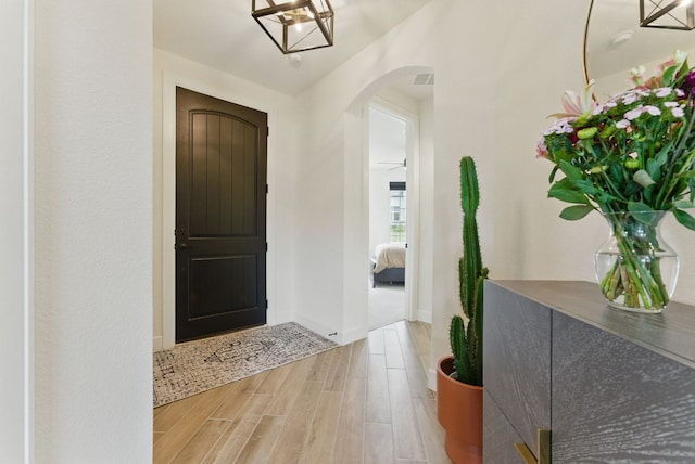 foyer featuring arched walkways and wood finished floors