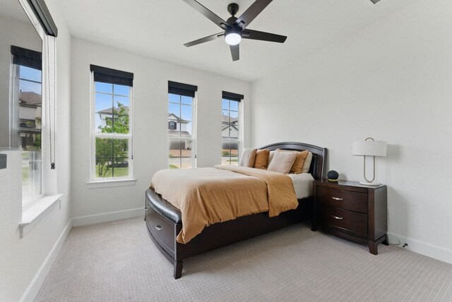 bedroom with light carpet, baseboards, and ceiling fan