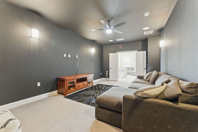 carpeted living room featuring ceiling fan and baseboards